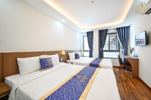 ein Hotelzimmer mit 2 Betten und einem Schreibtisch in der Unterkunft Napoly Hotel in Vũng Tàu