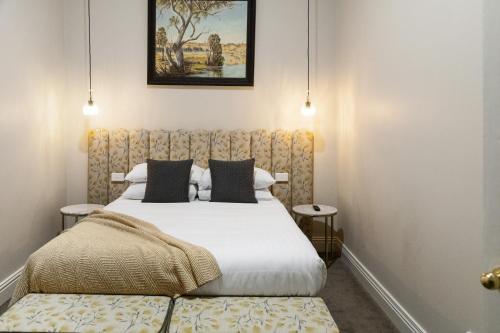 a bedroom with a large bed and two tables at Mount Gambier Hotel in Mount Gambier