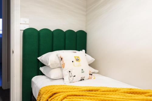 a bed with a green headboard and white pillows at Mount Gambier Hotel in Mount Gambier