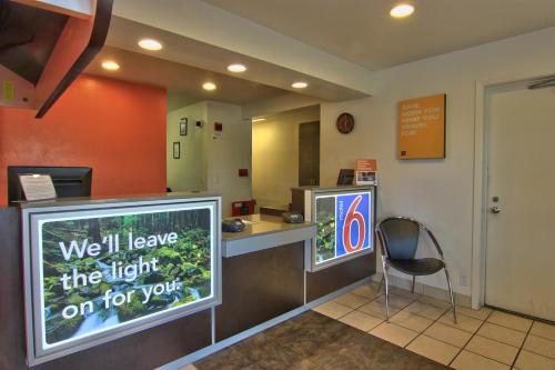 a waiting room with a counter with a sign at Motel 6-Woodland, CA Sacramento Airport in Woodland
