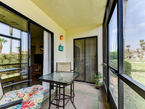 a balcony with a glass table and a chair at Ocean Village Club N16 in Saint Augustine