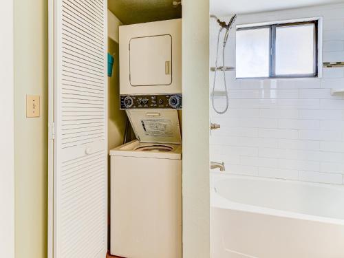 a washer and dryer in a bathroom with a tub at Ocean Village Club N16 in Saint Augustine