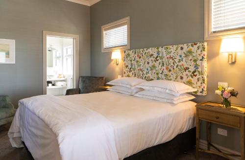 a bedroom with a large white bed with a floral headboard at 415 Marine Parade in Napier