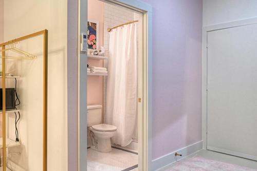 a bathroom with a toilet and a shower with a mirror at The Oleander Hotel Room 9 in Galveston