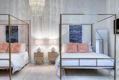 a bedroom with two beds and a chandelier at The Oleander Hotel Room 9 in Galveston
