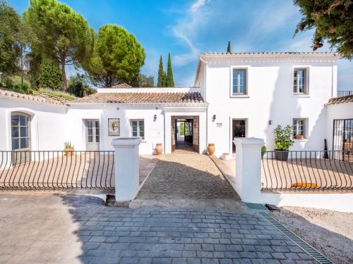 a white house with a gate and a driveway at Exclusive historic Villa in the heart of Andalucian - La Villa Magdalena in Ronda