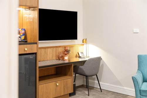 a room with a desk with a television and a chair at Mount Gambier Hotel in Mount Gambier