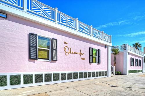 a pink building with the words the oleaway inn at The Oleander Hotel Room Number 3 in Galveston