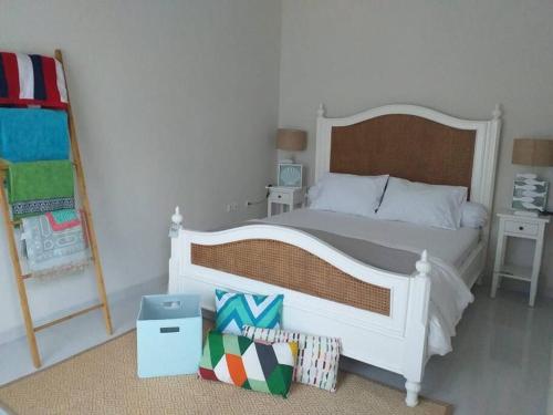 a bedroom with a large white bed and two tables at Maison de Q - 2 BR at Villa Ubud B 12 Anyer in Babagan