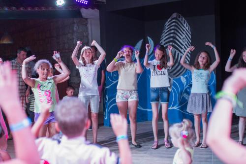 a group of children on a stage with their hands in the air at Le Bleu Hotel & Resort Kusadasi in Kusadası