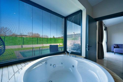 a bath tub in a room with a large window at Private Honeymoon Villa in Kayakoy