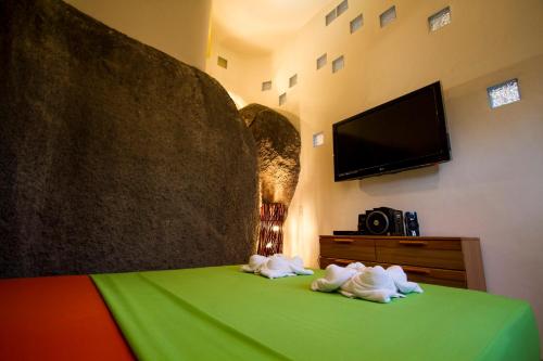a bedroom with a green bed with towels on it at Monkey Flower Villas in Koh Tao