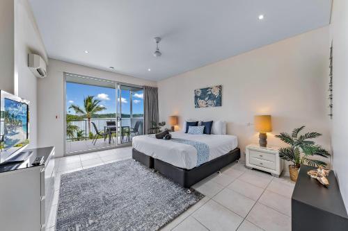 a bedroom with a bed and a view of the ocean at Baybliss Apartments 1 Bedroom WiFi in Shute Harbour