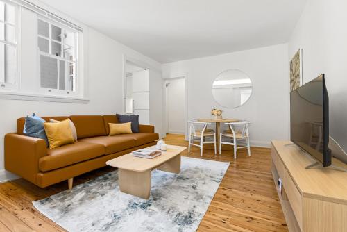 a living room with a couch and a tv at Mulwarree Avenue Apartments by Urban Rest in Sydney