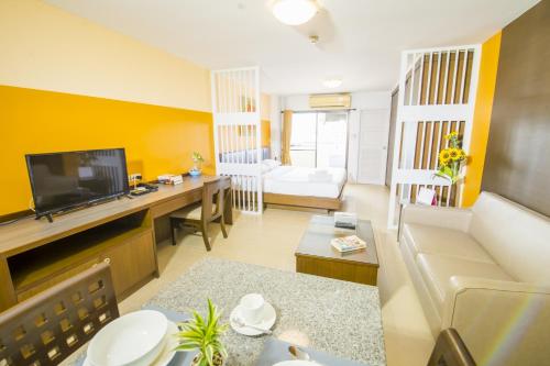 a living room with a couch and a tv at Sitara Place Serviced Apartment & Hotel in Bangkok