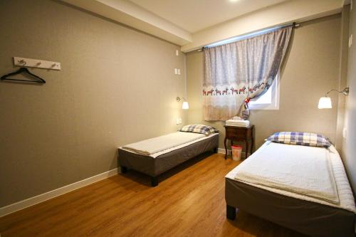 um quarto com duas camas e uma janela em Lighthouse Guesthouse em Mokpo