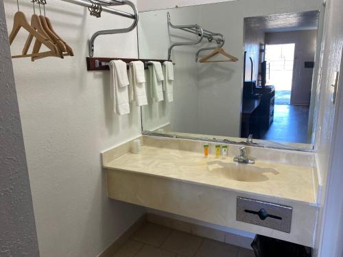 a bathroom with a sink with a mirror and towels at Luxury Inn in Montgomery