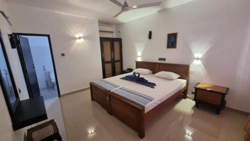 a bedroom with a bed and a television in it at Residence Jasmine in Aluthgama