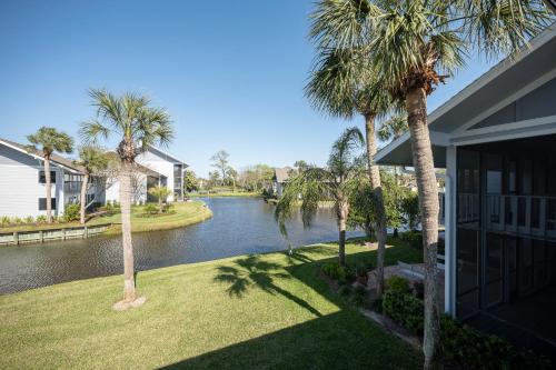 a house with palm trees next to a river at Deer Run 9767 in Ponte Vedra