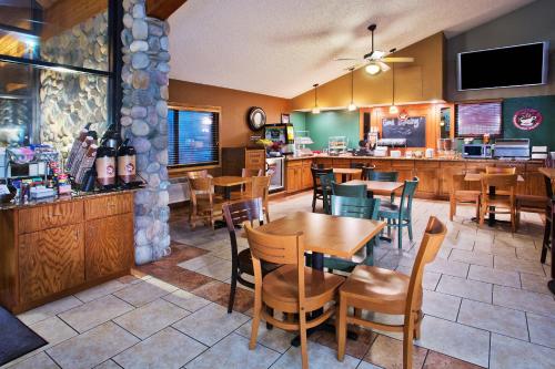 a restaurant with tables and chairs and a bar at AmericInn by Wyndham Lincoln North in Lincoln