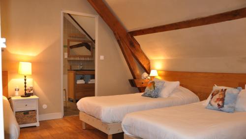 a bedroom with two beds and a mirror at Le Relais des Lacs Bourgogne Morvan in Planchez