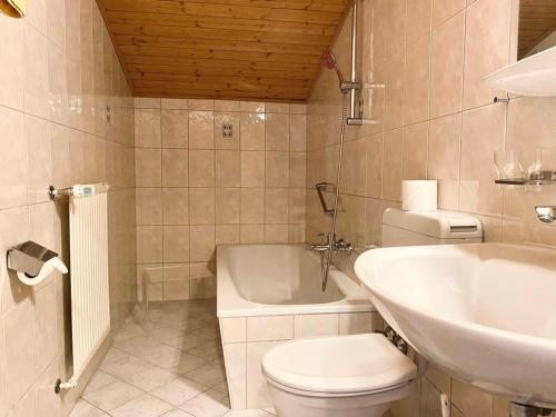 a bathroom with a toilet and a sink and a tub at Pension Katharinenhof uzavřen in Kaprun