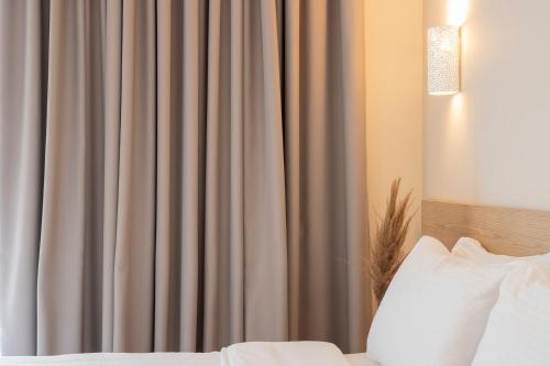 a bedroom with a bed and a curtain at Zefyros Sea View Hotel in Platamonas