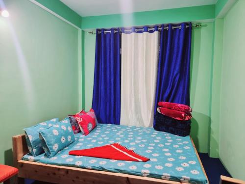 a bed with colorful pillows on it in a room at Neoravalley Homestay, Lava in Rishop