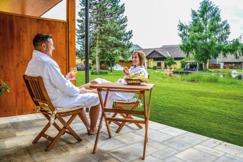 a man and woman sitting at a table on a patio at Landhaus Wilhelmer in Fohnsdorf