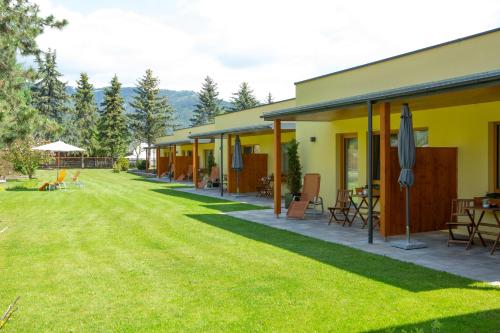 a row of houses with tables and chairs in a yard at Landhaus Wilhelmer in Fohnsdorf