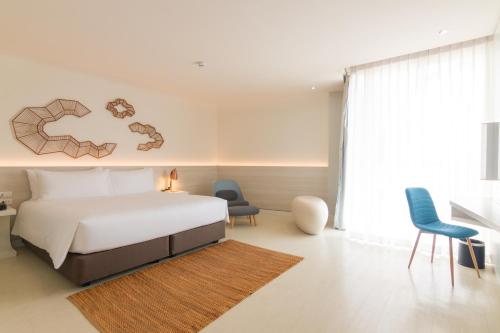 a bedroom with a bed and a table and chairs at VELA Dhi Udon Thani in Udon Thani