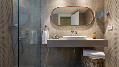 a bathroom with a sink and a shower with a mirror at U Splash Resort Eilat in Eilat