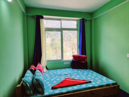 a small bed in a green room with a window at Neoravalley Homestay, Lava in Rishop