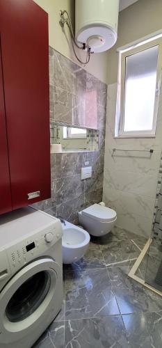 a bathroom with a washing machine and a toilet at Bellesuite Tirana in Tirana