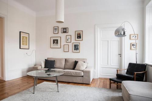 Exclusive and light 3 room appartment in SoFo 97sqm في ستوكهولم: غرفة معيشة مع أريكة وطاولة