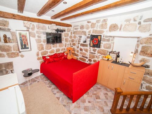 a red couch in a room with a stone wall at Apartment Alexandra in Kotor