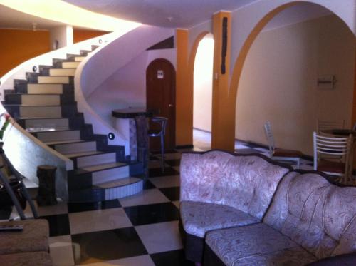 a living room with a couch and a staircase at Hostal Luren in Nazca