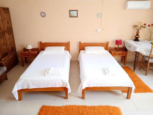 two beds in a room with two tables and a table at Akis Garden in Anemómylos