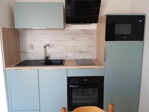 a small kitchen with a sink and a refrigerator at Appartement PLOEMEUR-Fort Bloqué in Ploemeur