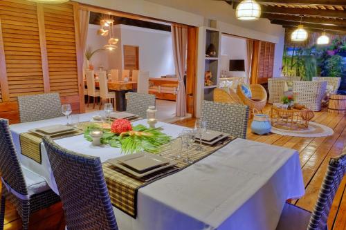 a dining room with a white table and chairs at Luxury Sakina Villa - Beachfront in Dzamandzar