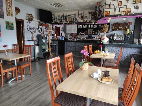un restaurante con mesas y sillas y un bar en Hostal La Llave, en Mave