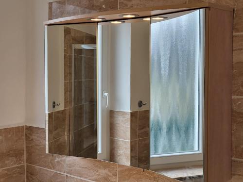 a shower with a glass door next to a window at Parkhotel Am Schwanenteich in Bad Sooden-Allendorf