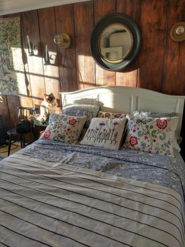 a bed with pillows and a mirror on the wall at Viinikan Tähti lemmikkiystävällinen kotimajoitus in Tampere