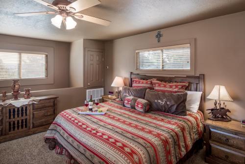 a bedroom with a bed and a ceiling fan at Adobe Hacienda, 3 Bedrooms, Sleeps 8, Gas Grill, Fenced Yard, WiFi in Ruidoso