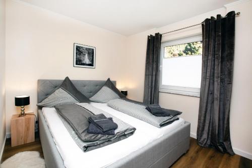 ein Schlafzimmer mit einem großen weißen Bett und einem Fenster in der Unterkunft Fewo Clemensberg Niedersfeld in Winterberg