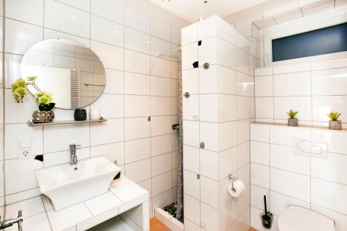 ein weißes Badezimmer mit einem Waschbecken und einem Spiegel in der Unterkunft Fewo Clemensberg Niedersfeld in Winterberg