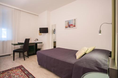 a bedroom with a bed and a desk with a computer at Hotel Buonconsiglio in Trento