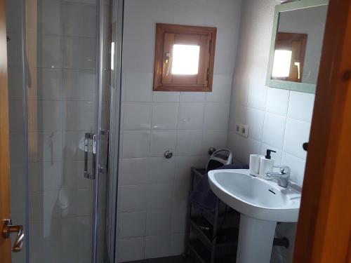 a white bathroom with a sink and a shower at Salicornia terrassa in Amposta