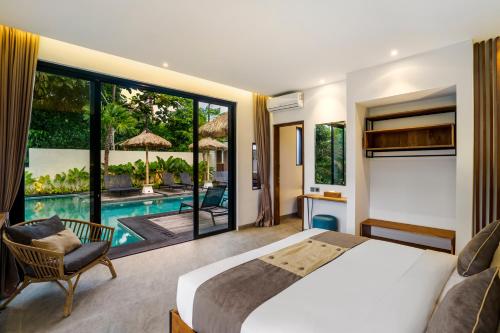 a bedroom with a large bed and a pool at Villa Lagoon by BaliSuperHost in Ubud