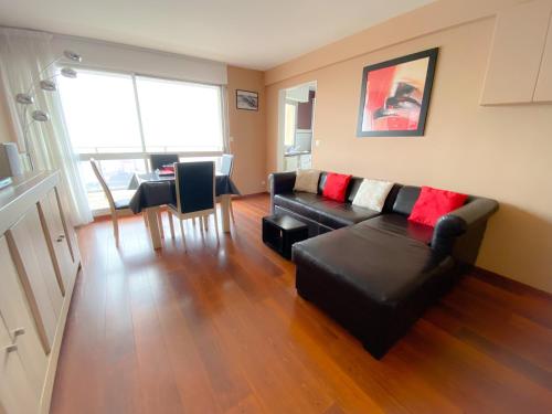 un salon avec un canapé noir et une table dans l'établissement The Beach, à Calais